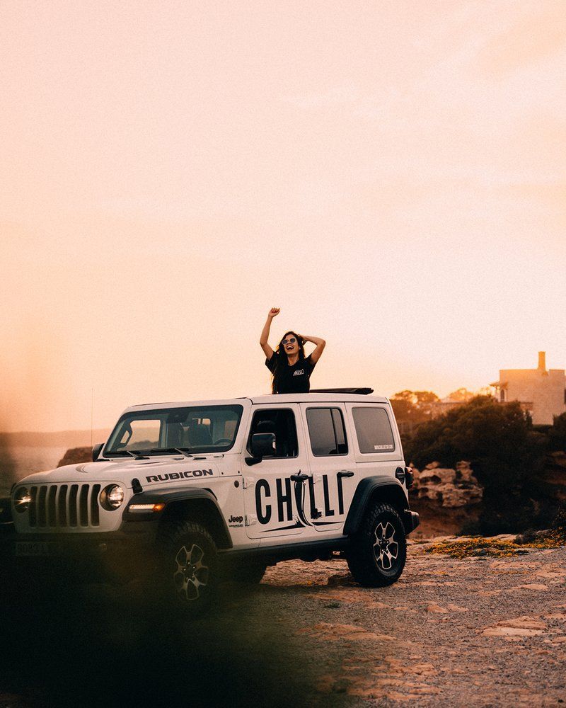 Jeep Rubicon Chilli al atardecer en Mallorca con modelo a bordo